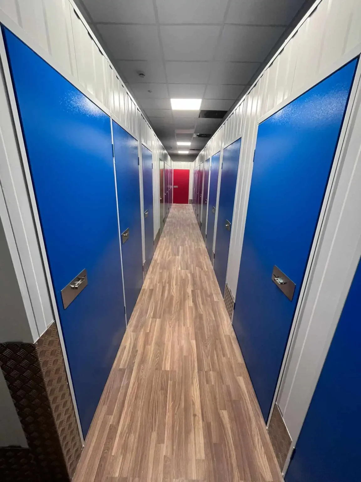 Pasillo interior con trasteros de puertas azules